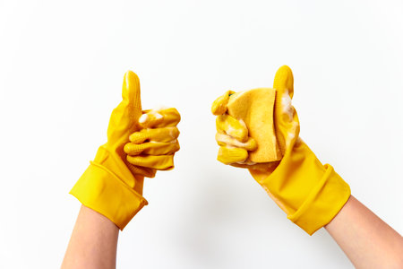 Hands in yellow gloves with sponge giving thumbs up on white backgroundの写真素材