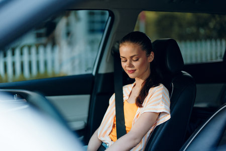 Calm woman sitting in a car with a relaxed expression, wearing a casual outfit The interior features...