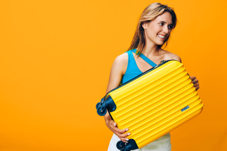 Vibrant image of a woman holding a yellow suitcase against a stunning bright orange backdrop