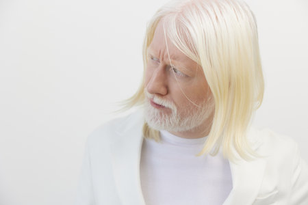 Elderly man with long white hair and beard in a minimalist white environment, showcasing a serene expression and thoughtful demeanor, perfect for studies on aging and wisdomの写真素材