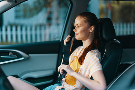woman fastening seatbelt in car, safety, travel concept, interior design, modern vehicle, casual...