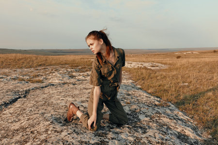 Woman sitting on rock in middle of field enjoying nature and traveling beautyの写真素材