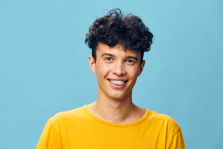 young man smiling, casual attire, bright background, cheerful expression, vibrant colors, friendly demeanor, portrait shot, joyful personality, modern style, casual fashionの写真素材