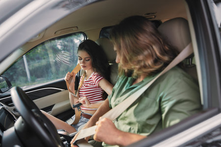 Young couple fastening seatbelts in a car interior, demonstrating safety and togetherness