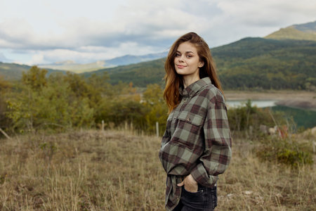 A young woman enjoying the serene beauty of a mountain lake in plaid shirt during a peaceful moment