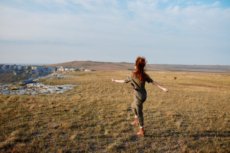 Freedom and joy woman running in a field with arms outstretched and hair blowing in the windの写真素材