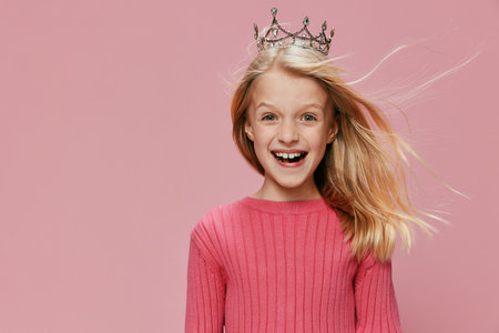Happy Childhood Princess A Cute Blonde Girl with a Crown and Pink Dress Celebrating her Birthday in a Magical Fairy Partyの写真素材