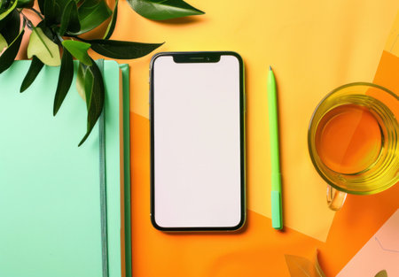 smartphone, notebook, stationery, greenery, office supplies, workspace, flat lay, creative layout, modern design A smartphone lies on a vibrant orange and green background, accompanied by stationeryの素材