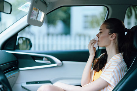 Woman sitting in a car, looking out the window, bright indoor environment, clean lines and modern design, captures a moment of reflection and serenityの写真素材