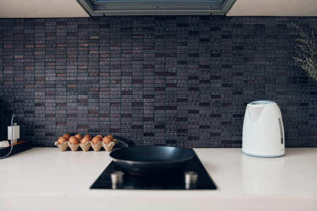 Modern Kitchen Interior with Oven, Coffee Maker, White Counter and Black Tiled Backsplash on Wall