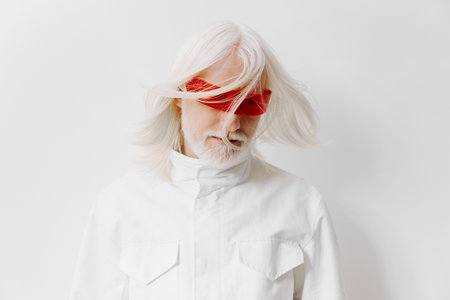 Abstract portrait of an elderly man with flowing white hair, wearing red blindfold glasses against a...