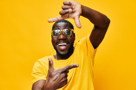 happy young man, cheerful expression, yellow background, gesturing with hands, stylish sunglasses,...