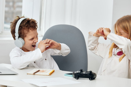 Smiling Siblings Playing and Taking Selfie with Smartphone in Cozy Home Interiorの写真素材
