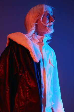 Stylish senior man with long white hair in a trendy outfit, wearing a leather jacket over a stylish...