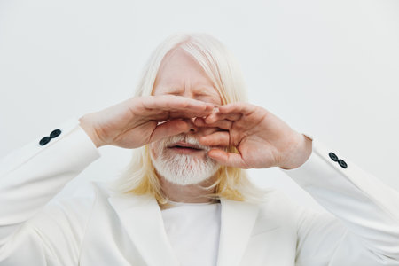 Portrait of a man with long white hair and beard, eyes closed, hands raised, wearing a white suit,...