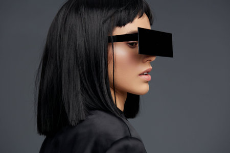 Blackhaired woman wearing glasses, looking away from the camera, expressing contemplation and serenity against a simple background, embodying thoughtful and introspective moodの写真素材