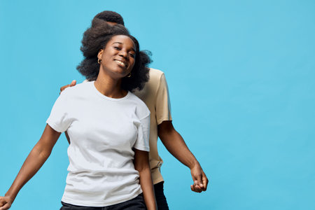 Happy woman smiling with joyful expression in casual white t shirt against a vibrant blue...