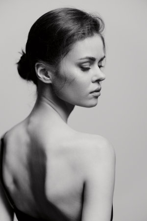 Elegant woman with a smooth back, captured in a black and white portrait, exuding grace and...