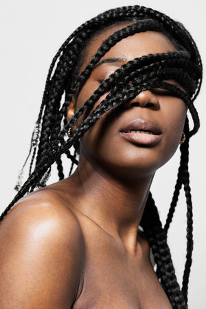 A beautiful young Black woman with braided hair, elegantly showcasing her natural beauty and...