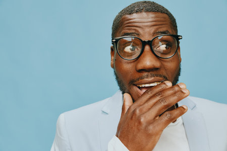 surprised expression, male model, smart casual attire, light blue background, joyful emotion, stylish glasses, engagement concept, contemporary fashion, expressive gesture, friendly atmosphereの写真素材