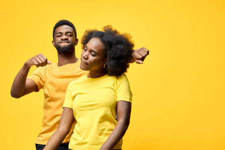 Two models joyfully celebrating their fitness journey in yellow outfits against a vibrant yellow background, showcasing positivity and empowermentの写真素材