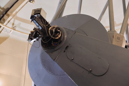Close up of intricate telescope mechanism with metal pole inside observatory building