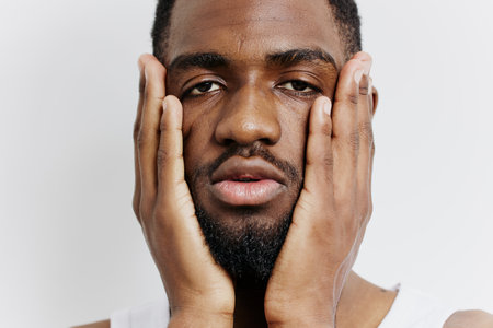 African american man in contemplation with hands on face, expressing deep thought and introspectionの写真素材