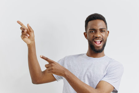 Confident young african american man in casual attire pointing directly at the camera, isolated on white backgroundの写真素材