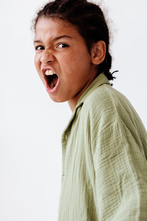 Furious young boy showcasing intense emotions against a blank backdrop