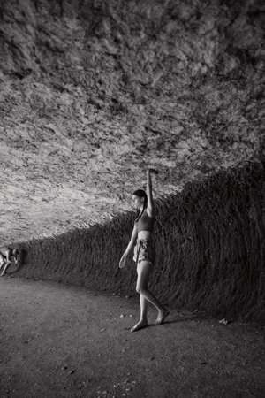 Woman standing in front of majestic rock formation, embracing the beauty of nature and adventureの写真素材