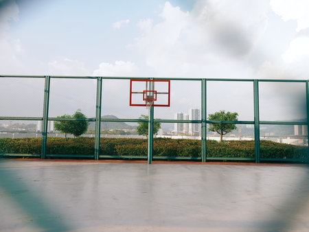 Outdoor basketball court with a hoop and city skyline viewの写真素材