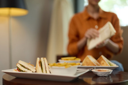 Healthy sandwiches with a side of fries, set on a table in a modern eatery, evoking warm feelings of comfort and satisfaction in a cozy atmosphereの写真素材