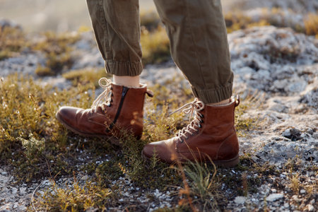 Solitary figure standing in the field wearing brown boots, concept of outdoors adventure and travel explorationの写真素材