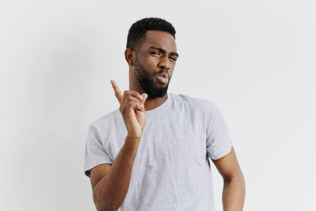 Confident young african american man giving ok sign against white backgroundの写真素材