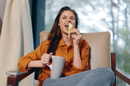Young woman enjoying healthy snack with tea in cozy indoor setting, capturing relaxation and wellness vibes during autumn daysの写真素材