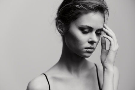 Thoughtful young woman with elegant features, in a minimalist black and white portrait, conveying introspection and emotional depth.の写真素材