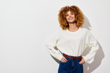 curly hair, smiling woman, casual fashion, light background, confident pose, modern style, lifestyle imagery, comfortable outfit, garment fashion, trendy lookの写真素材