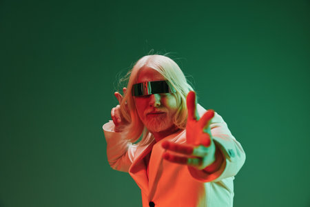 futuristic man in suit, neon lights, green background, stylish pose, modern aesthetics, retro vibe, unique fashion, artistic portrait, vibrant colors, creative expressionの写真素材