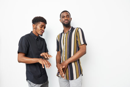 Two black men expressing joy in a modern setting, showcasing friendship and connection. Their...