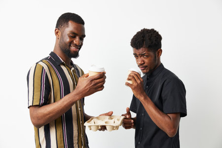 Cheerful black man enjoying coffee with a friend, vibrant colors, modern style, friendly atmosphere. Perfect capture of joy and connection in everyday moments.の写真素材