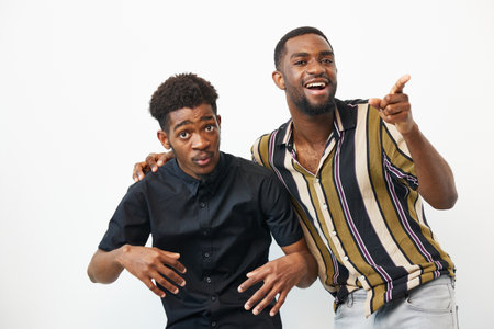Two African American men joyfully posing together, showcasing their vibrant personalities with...