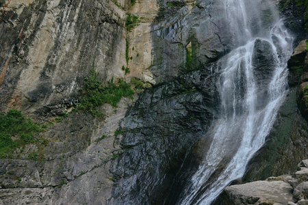 waterfall cascading natural rocky landscape with flowing water and green moss, peaceful outdoor...