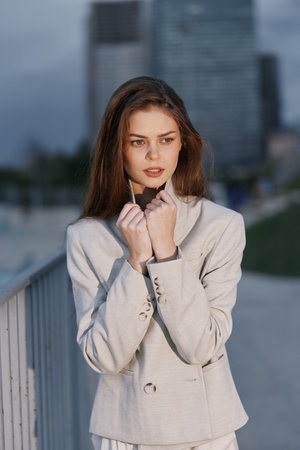 Confident woman in a business outfit outdoors with a city skyline, exuding professionalism and determination, ideal for corporate imagery.の写真素材