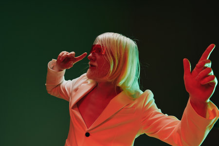 Stylish man with long white hair and sunglasses posing confidently on a dark green background,...