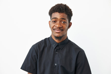 Black man smiling confidently against a white background, dressed in a casual black shirt. A vibrant...