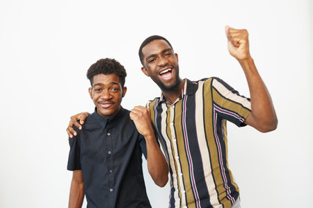 Two joyful African American men celebrating together, showcasing happiness and camaraderie. Their...