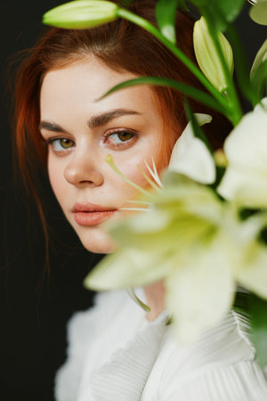 Close up portrait of a young woman with red hair, surrounded by white flowers, conveying emotional beauty and tranquility, suitable for wellness and lifestyle themesの写真素材