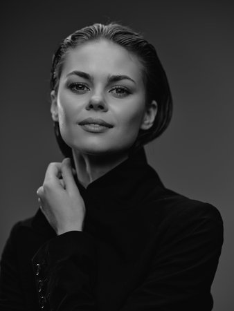 Black and white portrait of a confident woman with wet hair wearing a dark turtleneck sweater,...