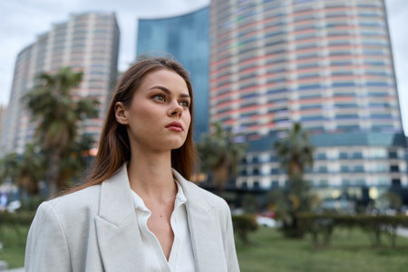 Woman confident in white blazer with urban background, thoughtful expression, modern business style,...
