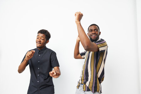 Joyful African American men dancing together, celebrating life with genuine smiles and vibrant energy. Perfect for conveying fun and camaraderie in photography.の写真素材